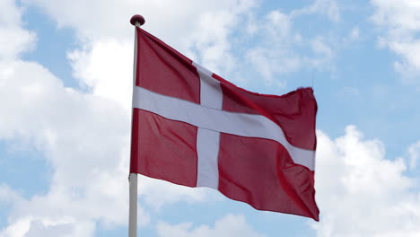 Dänische-Flagge,-Die-An-Windigem-Tag-Gegen-Himmel-Mit-Wolken-Flattert