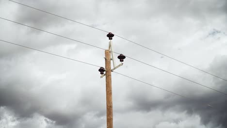 Wooden-Telephone-Pole-And-Cables-With-Dark-Gloomy-Sky-In-The-Background