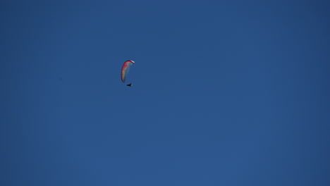 Ein-Bunter-Fallschirm-Fliegt-In-Den-Blauen-Himmel-über-Den-Schweizer-Alpen,-Obwalden