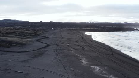 Extremo-Motor-Cross-Personas-En-Playa-Volcánica-Negra,-Cala-Sandvik,-Islandia