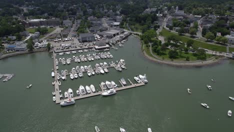 Aerial-view-over-boats-at-the-Safe-Harbor-Plymouth-marina,-sunny,-summer-day-in-USA---Tilt,-drone-shot