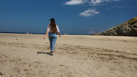 Mujer-Joven-Caminando-Sobre-La-Cálida-Arena-De-La-Playa-De-Mallorca
