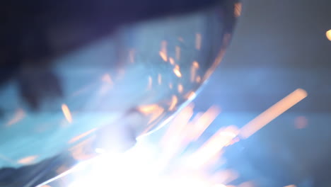 Welders-sparks-flying-around-reflecting-off-face-shield-creating-a-beautiful-visual