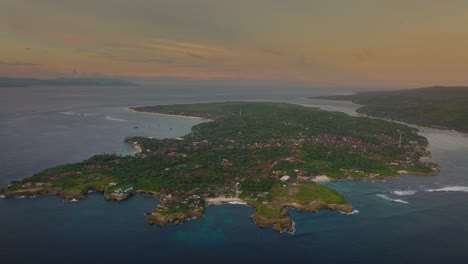 Sunset-at-Nusa-Lembongan-turning-towards-Nusa-Ceningan,-aerial-view-of-tropical-island,-dusk