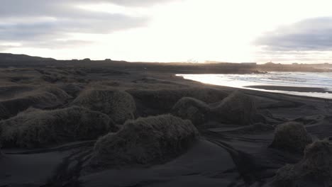 Golden-hour-sunrise-with-bright-sunshine-in-sky-at-black-sand-beach-Sandvik