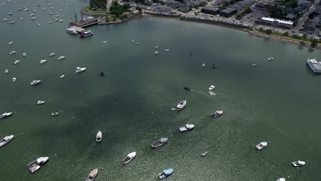 Anchored-boats-and-the-townscape-of-Plymouth,-sunny,-summer-day-in-USA---Tilting-aerial