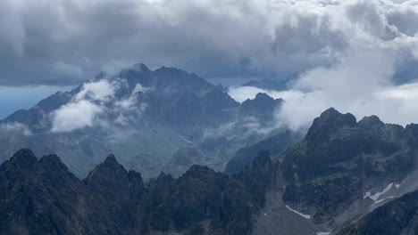 Panorama-high-above-the-clouds,-view-of-jagged-peaks-of-the-High-Tatra-Mountains