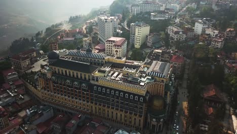 The-sun-glistens-off-a-grand-building-in-Sapa,-Vietnam,-on-a-humid-foggy-day