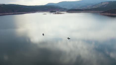 Barcos-En-Aguas-Tranquilas-Y-Reflectantes-Del-Lago-Del-Embalse-De-Flaming-Gorge,-Utah---Antena