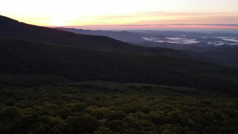 Aerial-push-over-treetops-below-grandfather-mountain-nc-at-sunrise