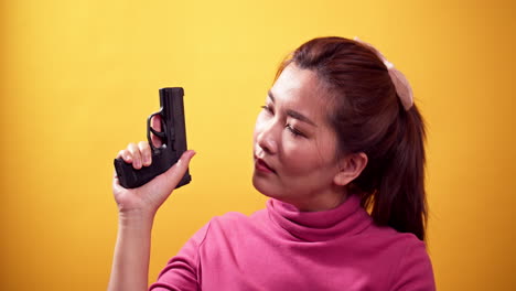 Serie-Asiatische-Frau-Mit-Einer-Pistole-Bereit-Zur-Selbstverteidigung-Auf-Hellgelbem-Hintergrund
