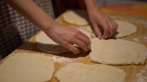 Hands-close-up-stretching-dough-for-steps-in-Hungarian-food-Langos,-home-kitchen
