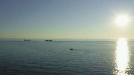 Fischerboot-Und-Frachtschiffe,-Die-Während-Des-Sonnenuntergangs-In-Der-Nähe-Des-Seehafens-Batumi-In-Georgien-über-Die-Meereslandschaft-Segeln