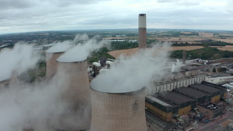 Close-up-circling-drone-shot-of-Large-power-station-cooling-towers-and-chimney