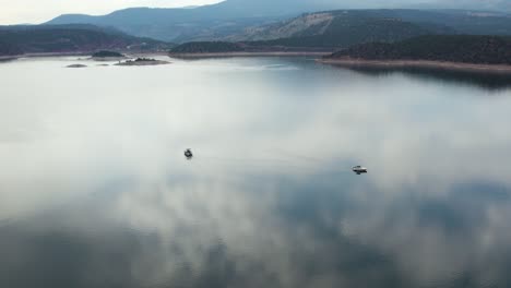 Clouds-Sky-Reflection-on-Lake-Water-Surface-with-Boats-at-Flaming-Gorge-Reservoir,-Wyoming---Aerial-Orbit