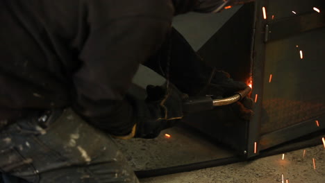 Professional-welder-making-sure-heavy-metal-sheets-are-correctly-fixed-to-one-another-before-the-next-stage-of-production