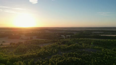 Slow-aerial-drone-shot-of-beautiful-sunrise-over-trees-and-fields-in-kent