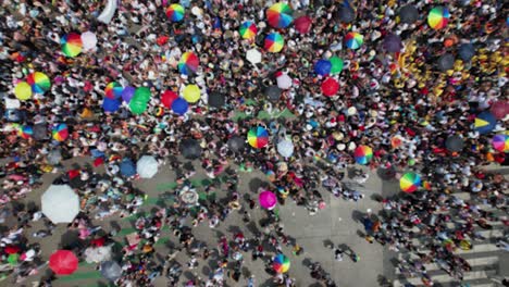 Isolierter-Regenbogenschirm-Inmitten-Einer-Großen-Menschenmenge,-Die-Stolz-Auf-Den-Straßen-Der-Stadt-Feiert---Luftbild