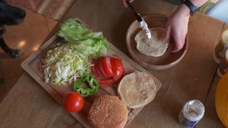 Cook-preparing-a-delicious-veggie-burger-adding-vegan-mayo-in-4K-slow-motion