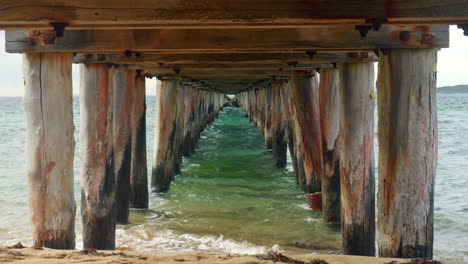 SLOW-MOTION-Perspective-View-Underneath-Old-Wooden-Jetty