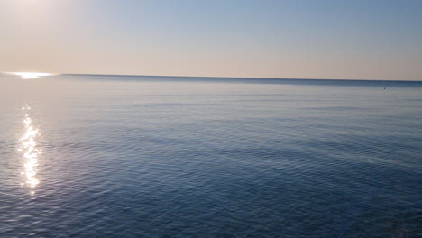 Calm-water-surface-and-blue-sky-at-sunrise