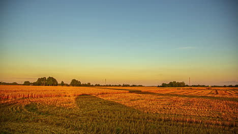 Shadows-of-a-rolled-bale-of-hay-and-people-working-stretch-into-the-farmland-at-sunset---time-lapse