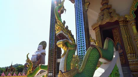 Low-angle-shot-of-a-chinese-golden-fat-Buddha-in-Wat-Plai-Laem,-Koh-Samui,-Thailand-on-a-bright-sunny-day