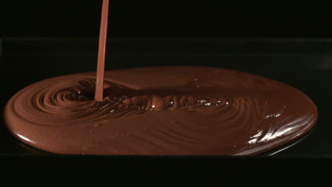 Mezclando-Cubos-De-Chocolate-Con-Polvo-De-Cacao-Fino,-Sobre-Un-Fondo-Negro,-Mezclándolos-Con-Un-Bol-De-Plata-1