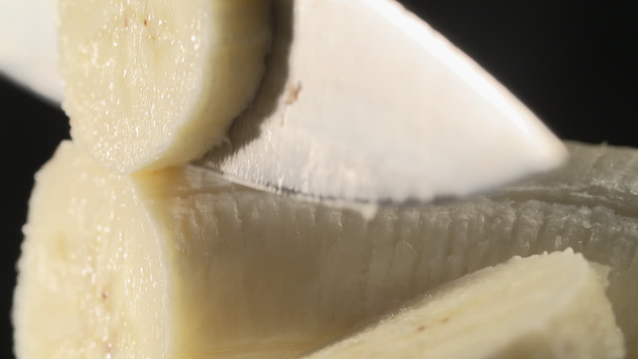 1280px x 720px - Premium stock video - Utting a banana on a black stool and a black  background with a chef's knife, high quality sexy close-up, food porn