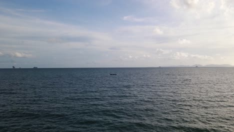 Aerial-drone-forward-moving-shot-flying-over-long-tail-fishing-boat-passing-through-deep-sea-along-Ao-Nang-Beach,-Krabi,-Thailand