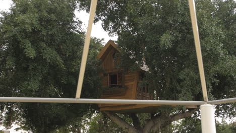 Beautiful-children's-treehouse,-on-a-big-tree,-passing-shed-poles,-slow-motion-dolly-to-the-right