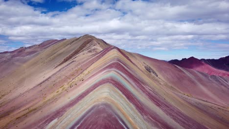 Drone-shot-of-a-rocky-ridge-with-reddish-ore-on-the-rainbow-mountain-in-Vinicunca