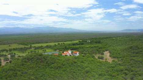 AERIAL---Epic-shot-of-an-hacienda-in-the-middle-of-a-forested-area,-spinning-shot