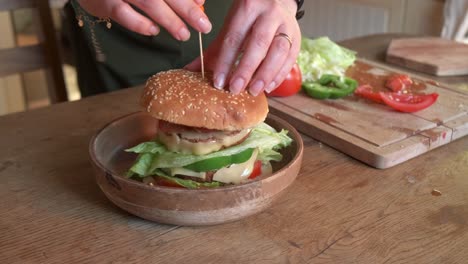 Cook-finishing-preparing-a-delicious-vegan-burger-with-veggie-in-4K-slow-motion