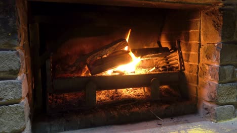 A-fireplace-with-freshly-added-logs-that-are-starting-to-catch-fire