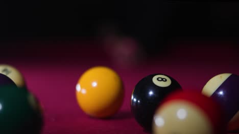 Eye-level-slow-motion-frontal-shot-of-man-hitting-cue-ball-and-breaking-rack-on-the-pool-table