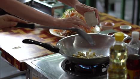 2-Personen-Kochen-Tofu-In-Einem-Wok-Bei-Mittlerer-Hitze,-Um-Pad-Thai-In-Einer-Außenküche-In-Bangkok,-Thailand,-Zeitlupe-Zu-Kochen