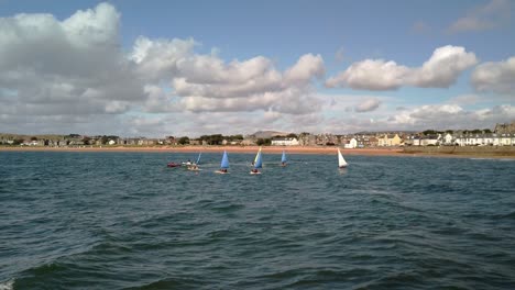 Young-pupils-being-trained-in-small-sailboats-protected-by-motorboat-overseers-on-choppy-seas