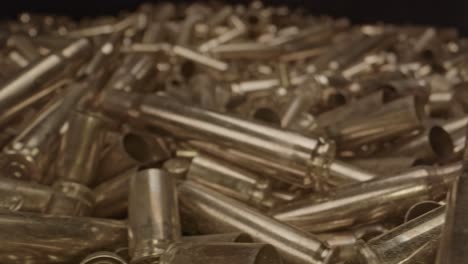 Close-dolly-of-fired-shell-cases-of-several-calibers-and-firearms