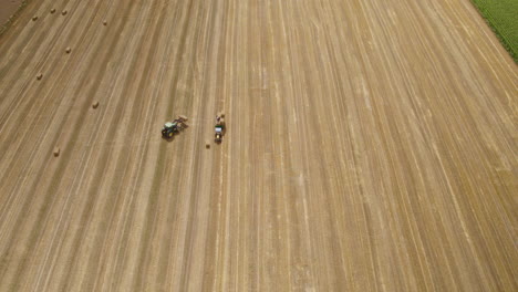 Aerial-Birdseye-view-above-farming-tractors-in-preparation-cultivation-of-harvest-wheat-fields