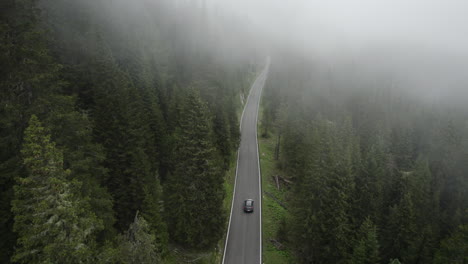 Unheimliche-Bergstraße-Durch-Dichten,-Nebelverhangenen-Alpenwald;-Antenne