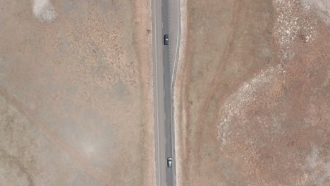 Aerial-top-down,-cars-on-road-trip-in-USA-driving-on-straight-road-in-dry-desert