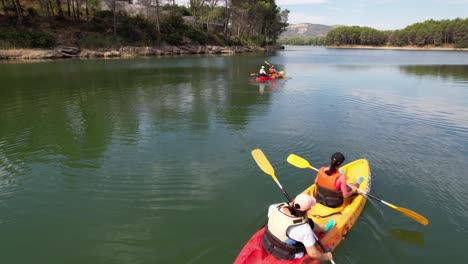 FAMILY-FUN,-enjoying-riding-colorful-kakacs-in-a-green-water-lake-in-Castellon,-Spain