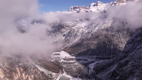 High-altitude-lake-in-scenic-alpine-mountain-range-Dolomites-during-winter,-aerial