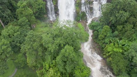 Aerial-Overhead-Tropical-Treetops-With-Tilt-Up-View-Of-Cascading-Wachirathan-Waterfalls