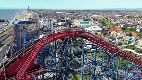 Aerial-drone-flight-over-Blackpool-Pleasure-Beach-slowly-panning-to-reveal-a-stunning-view-of-the-coastline-and-Blackpool-Tower-in-the-distance