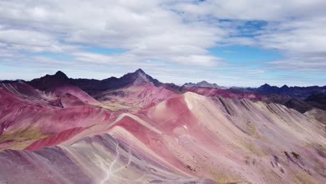 Circular-aerial-shot-of-a-valley-with-red-mineral-in-the-mountain-of-seven-colors,-Vinicunca