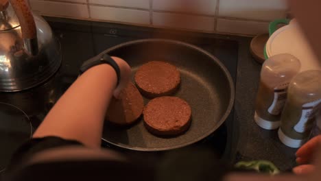 Vista-Sobre-El-Hombro-De-Un-Cocinero-Cocinando-Hamburguesas-Vegetarianas-En-Una-Estufa-En-Cámara-Lenta-De-4k