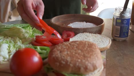 Umlaufende-Ansicht-Eines-Kochs,-Der-Einen-Köstlichen-Vegetarischen-Burger-Zubereitet-Und-Vegane-Mayo-In-4k-Zeitlupe-Hinzufügt
