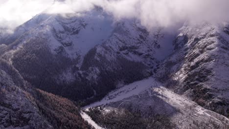 Reveal-shot-of-grand-high-mountain-face-during-winter-in-Dolomites-alps,-aerial